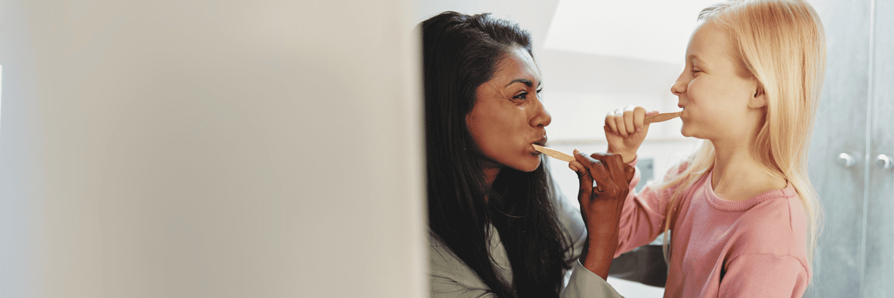2 young girls and a young boy smiling in the park